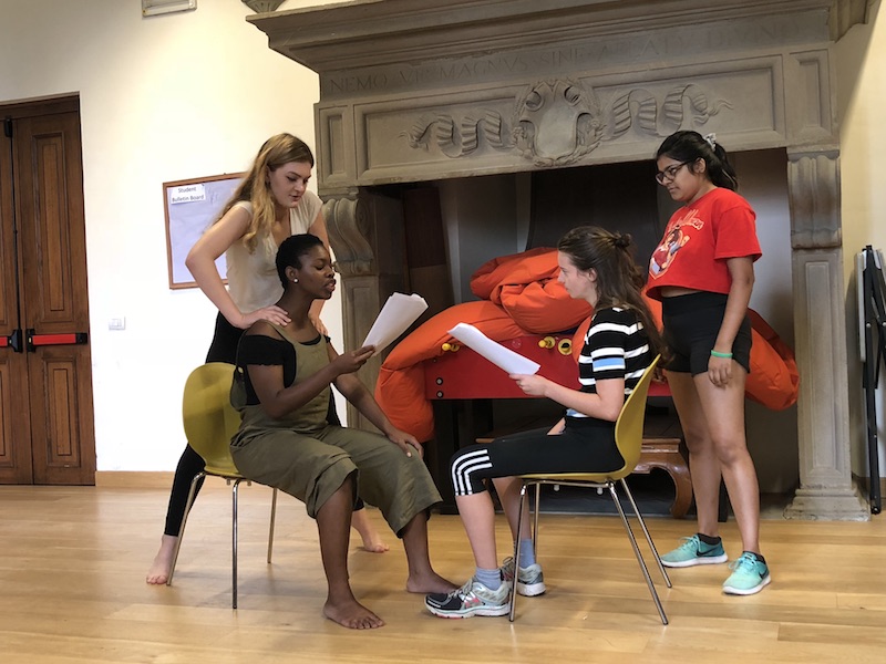 Commedia dell'Arte students doing scene work in the studio, holding scripts.